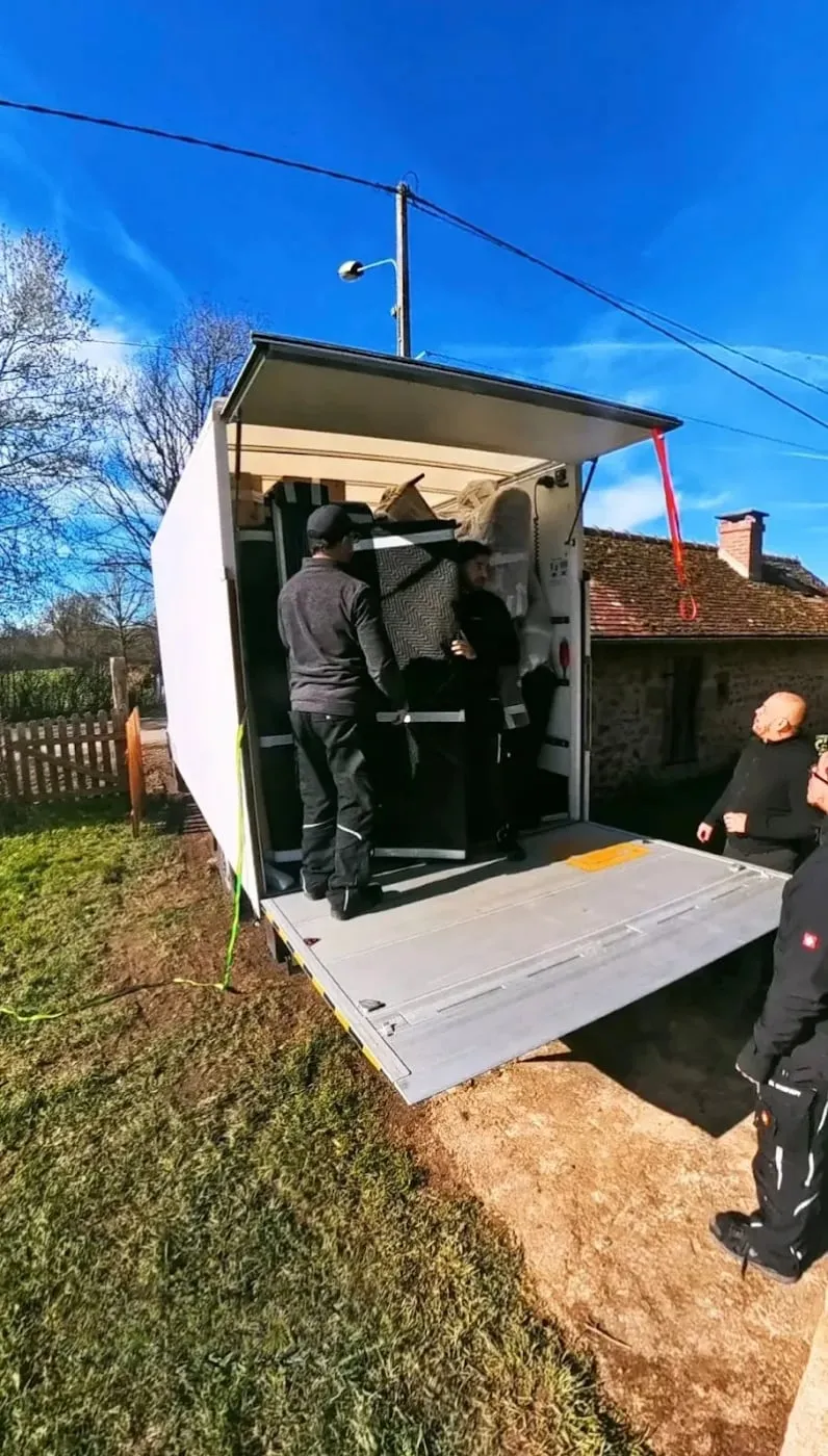 Chargement d’un camion DL Company devant une maison de campagne