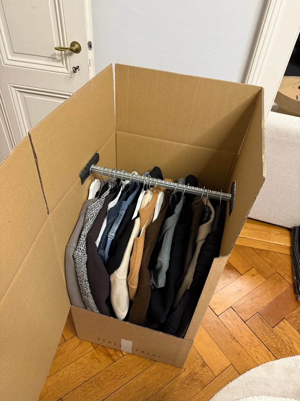 Carton penderie avec les vêtements sur cintres