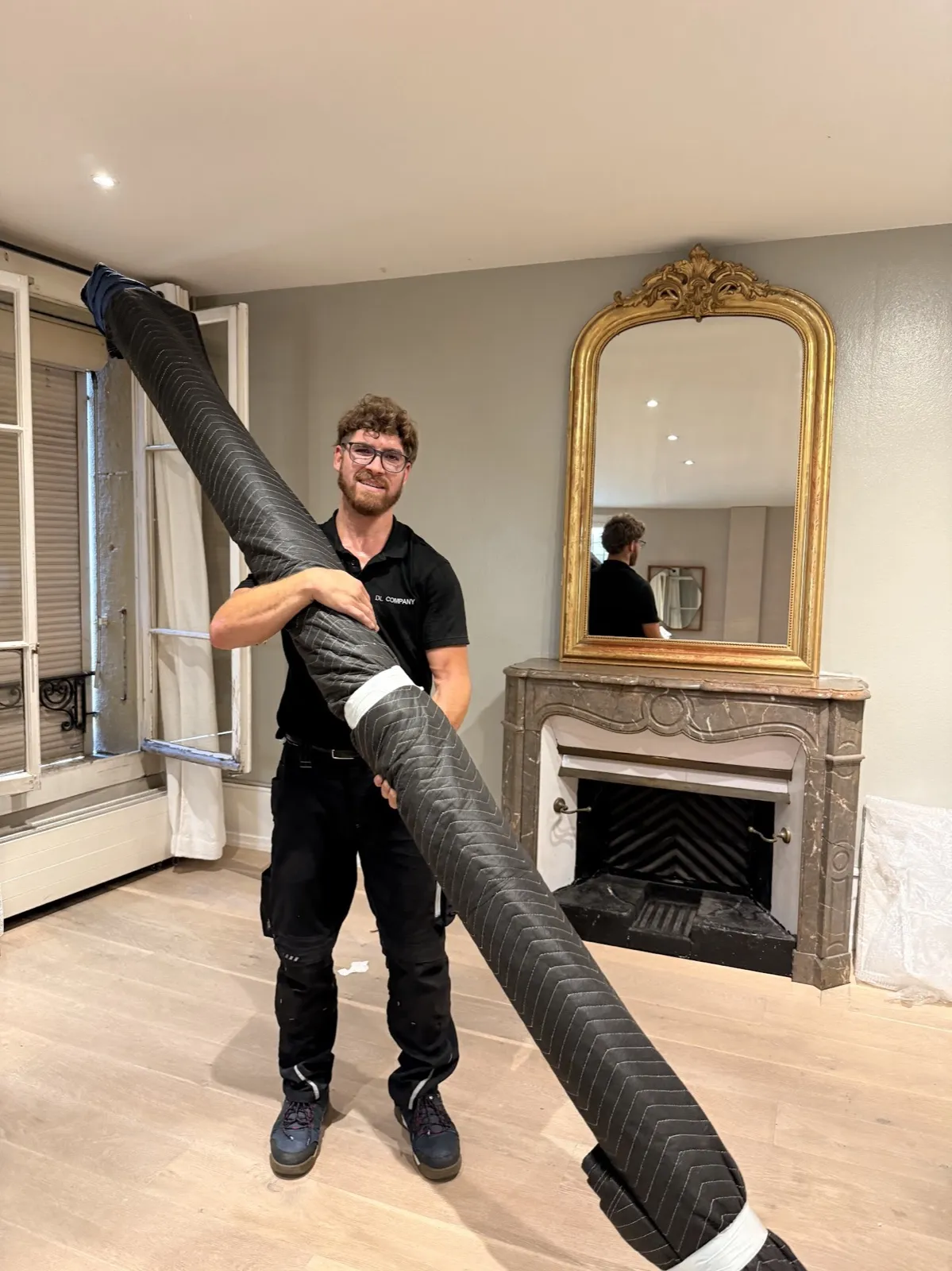 Un déménageur porte une pièce longue protégée