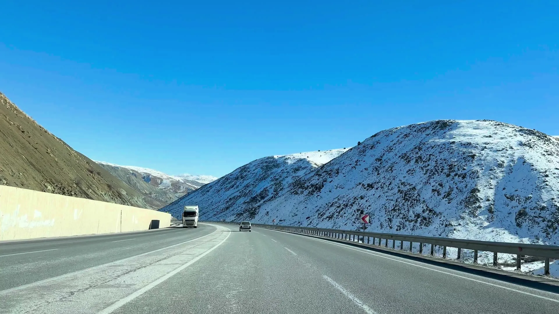 Camions sur une route de montagne enneigée : déménagement international au départ de Genève