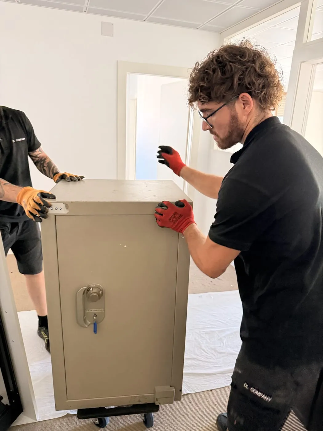Manutention d’un coffre-fort avec des gants de protection
