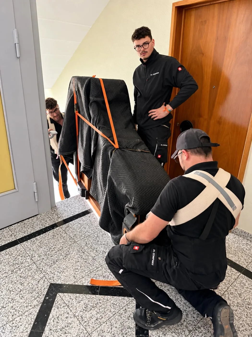 L’équipe sangle un piano protégé sur un palier