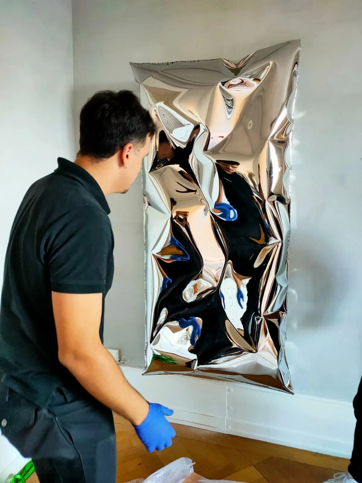 Installation d’une sculpture murale en acier poli miroir pour Objects With Narratives