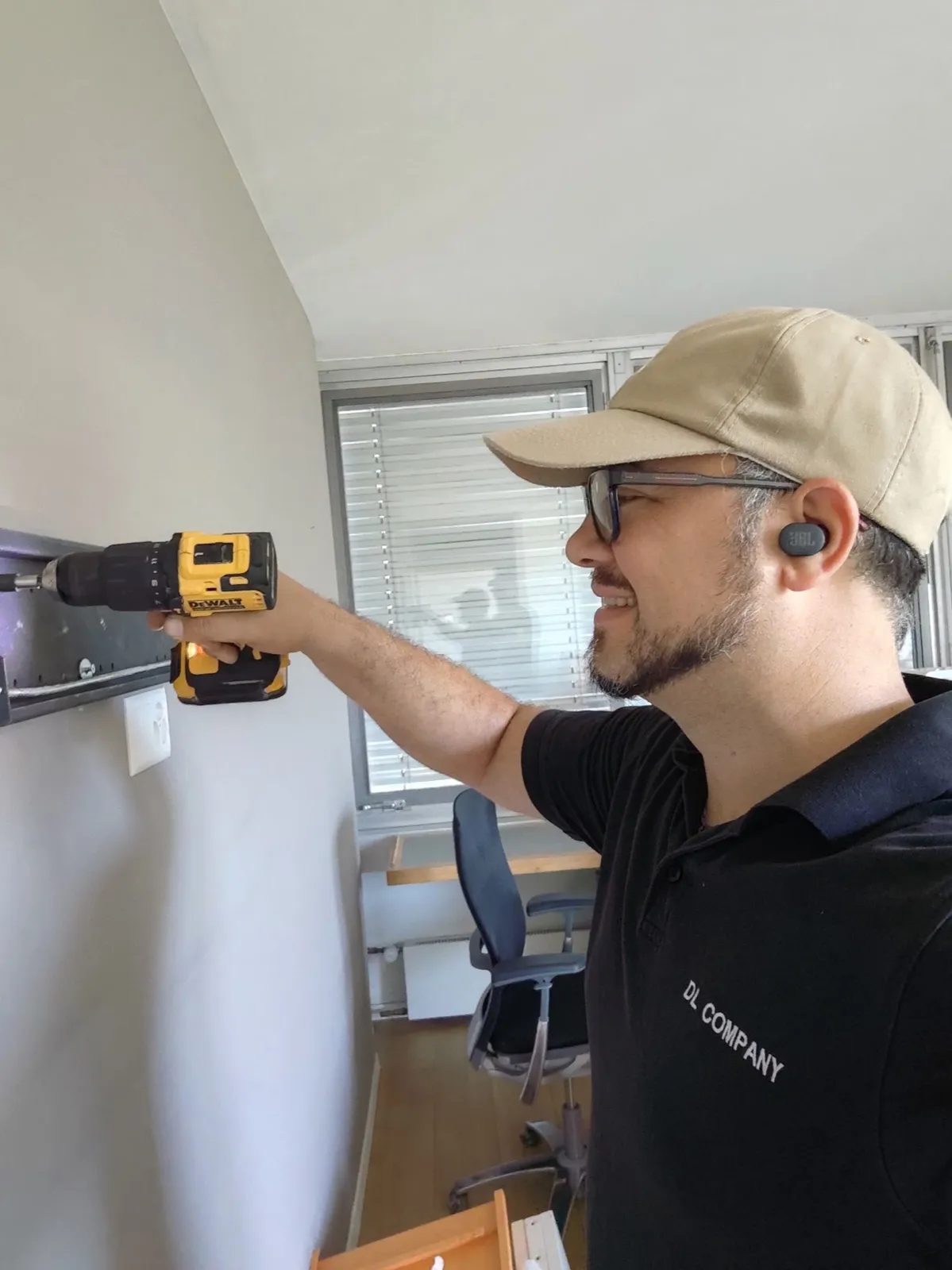 Technicien qui fixe un élément au mur